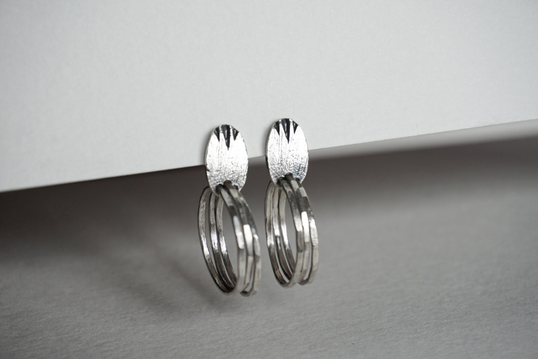 Silver oval textured stud earring with hammered circles